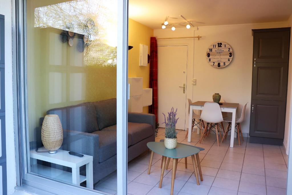 un salon avec un canapé et une table dans l'établissement Appartement Cabourg près de la plage, à Cabourg