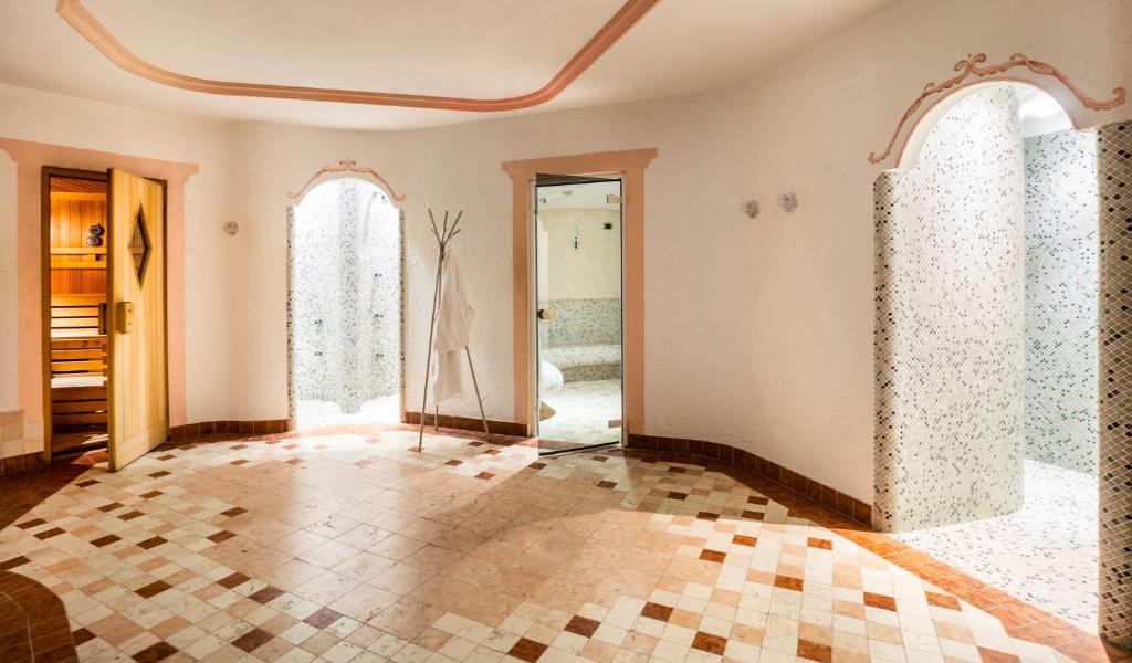 an empty room with windows and a tiled floor at Garni Aritz in Campitello di Fassa