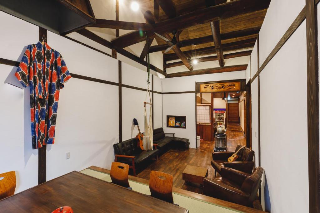 ein Wohnzimmer mit Tisch und Stühlen in der Unterkunft Couch Potato Hostel in Matsumoto