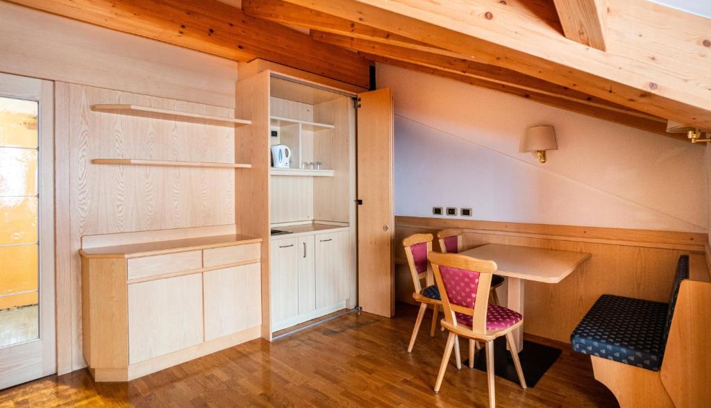 a kitchen with a table and chairs in a room at Garni Aritz in Campitello di Fassa
