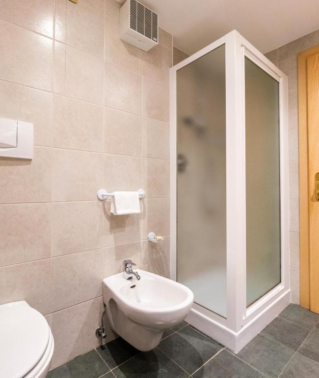 a bathroom with a toilet and a sink and a shower at Garni Aritz in Campitello di Fassa