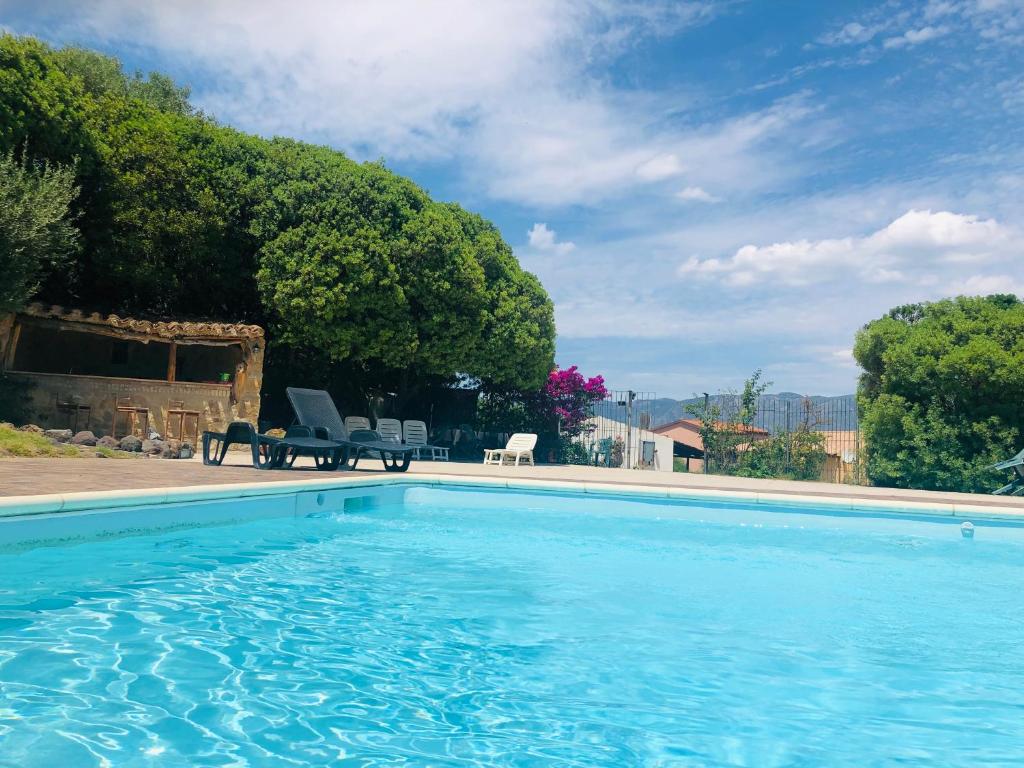 a swimming pool with two chairs and a table at Agriturismo Il Paradiso in Iglesias