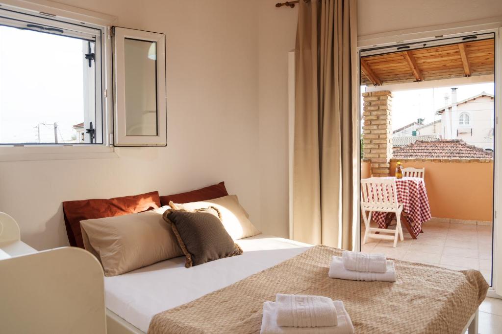 a bedroom with a bed and a large window at Home Style Apartment in Lefkimmi