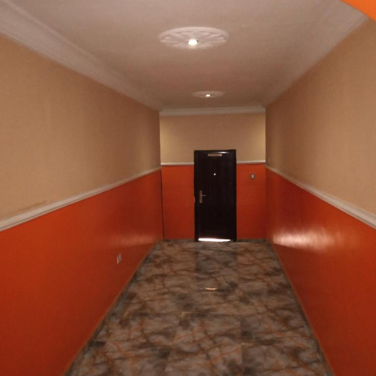 an empty room with a black refrigerator in the corner at LARRYDAM HOTEL AND SUITES in Ilesa