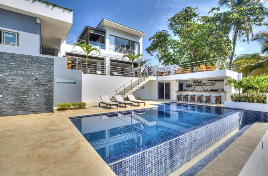 a house with a swimming pool in front of it at Garten Hotel in El Zonte