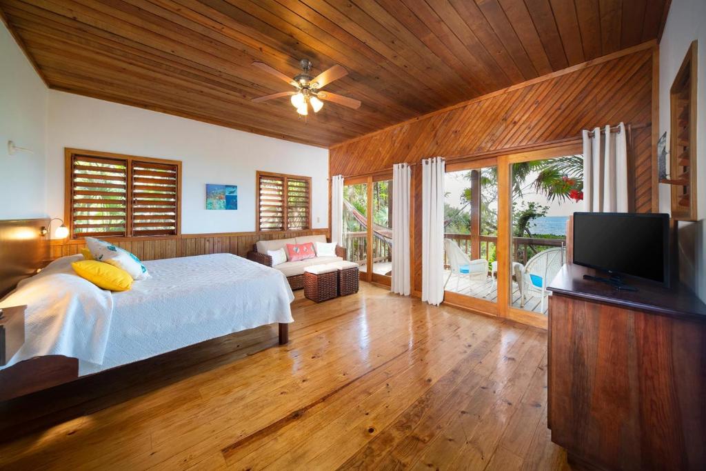 a bedroom with a bed and a flat screen tv at Cocolobo Resort in West End