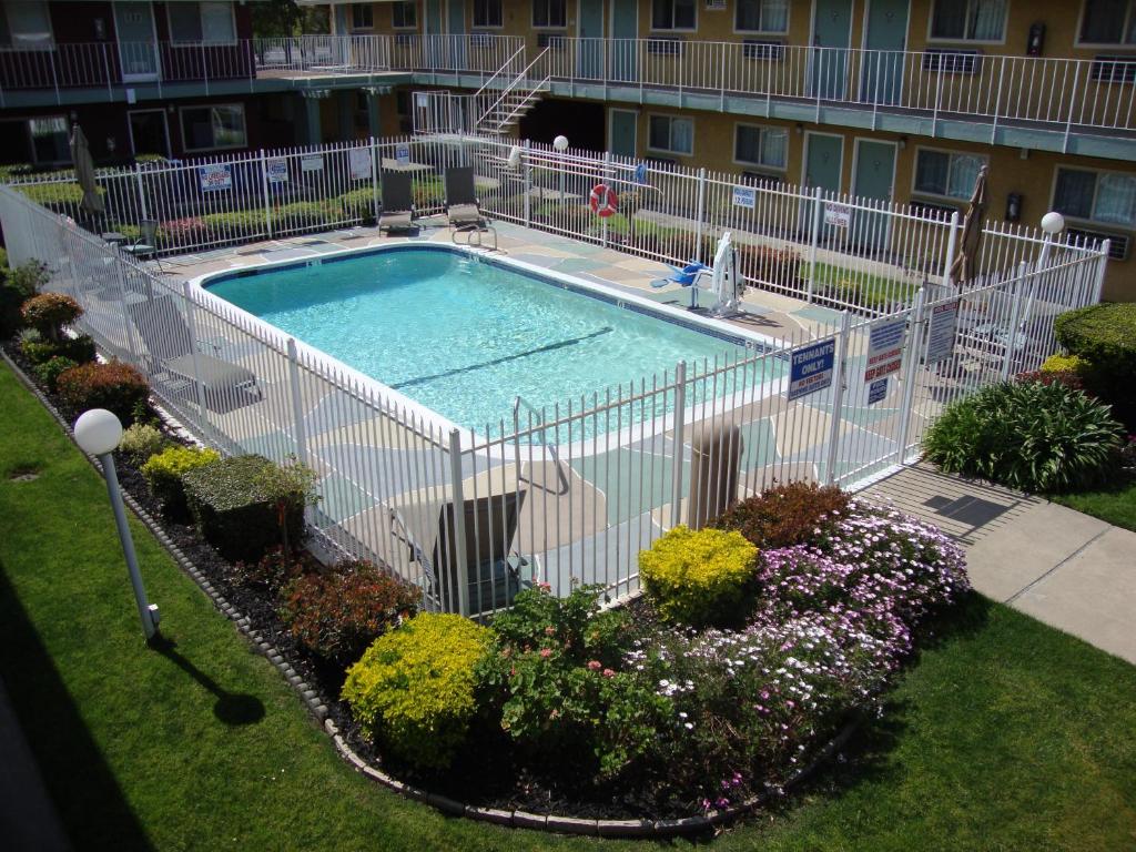 uma piscina vazia num quintal com flores em Oasis Inn Sacramento- Elk Grove em Sacramento
