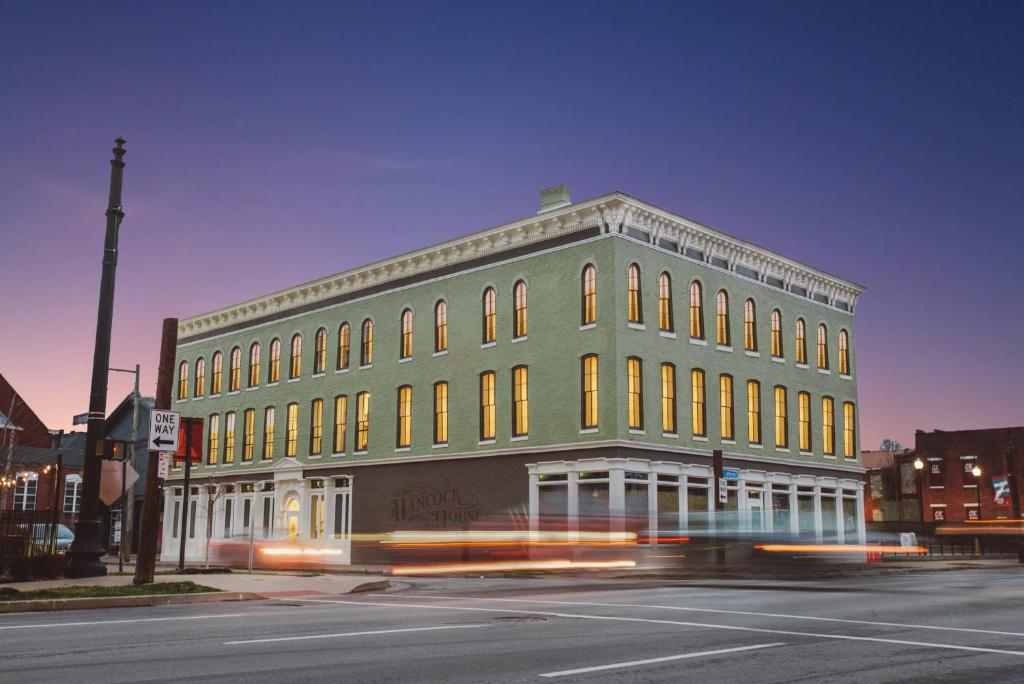 a green building on the corner of a street at Hancock House in Louisville