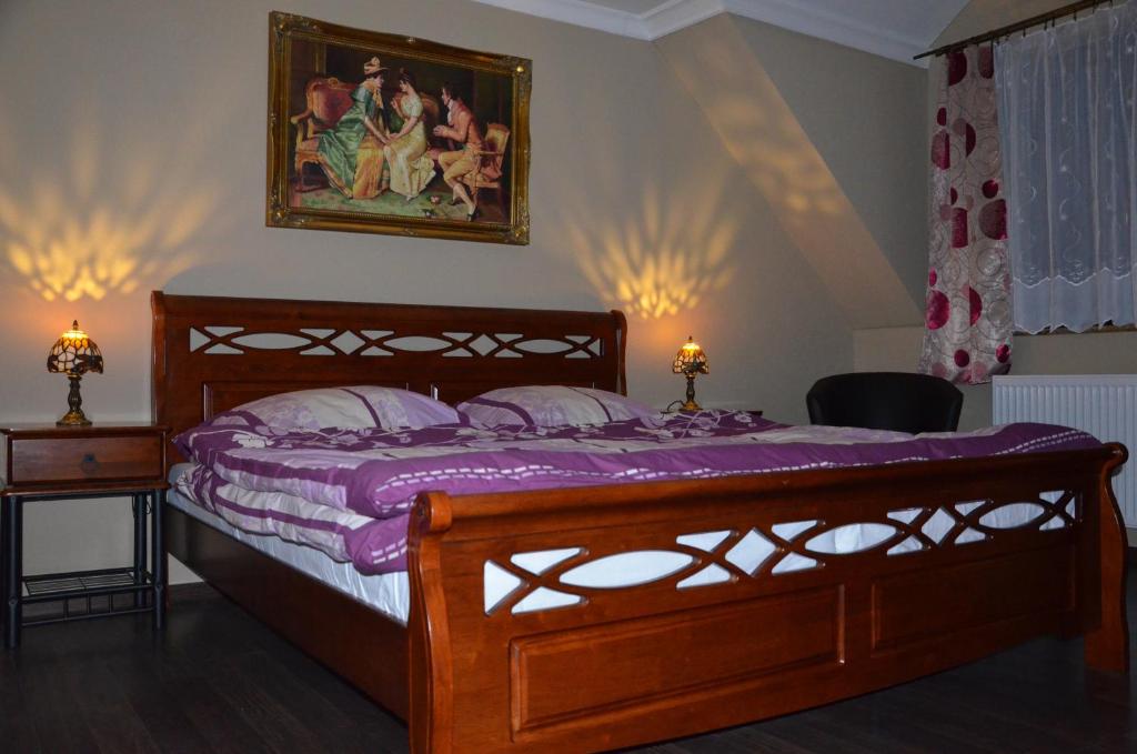 a bedroom with a wooden bed and a painting on the wall at Palatín in Čachtice