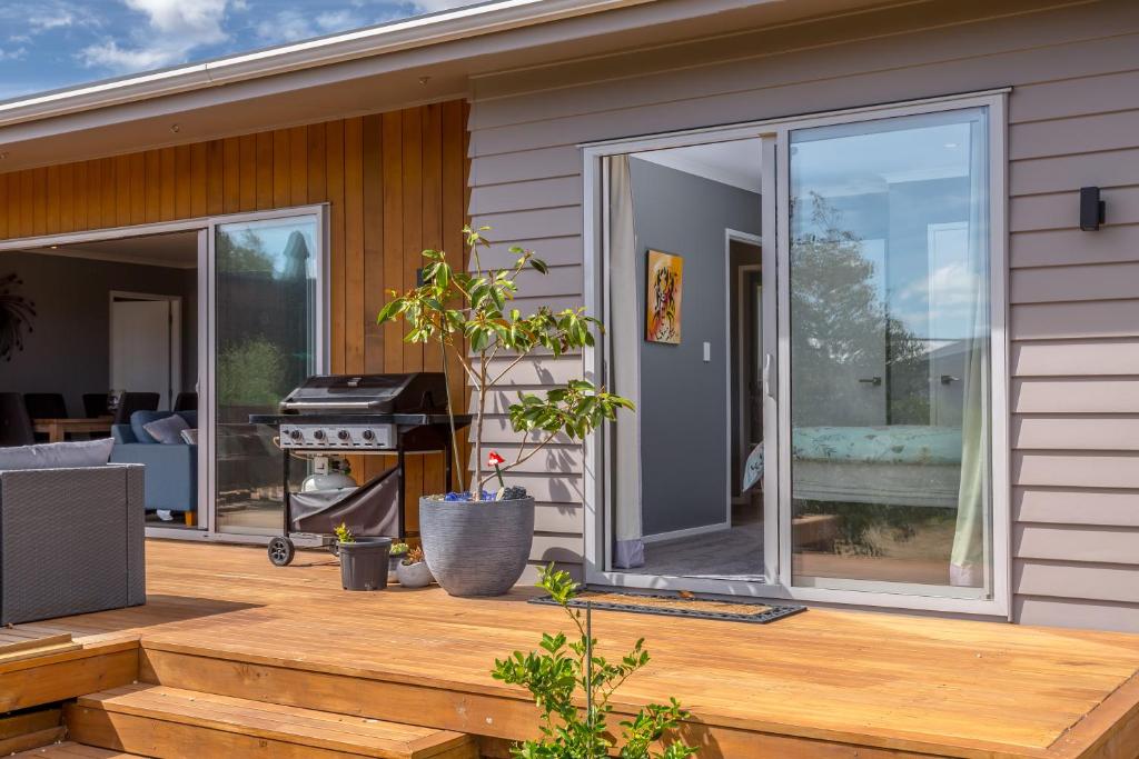 a large sliding glass door on a deck with a grill at Fern Haven in Martinborough 