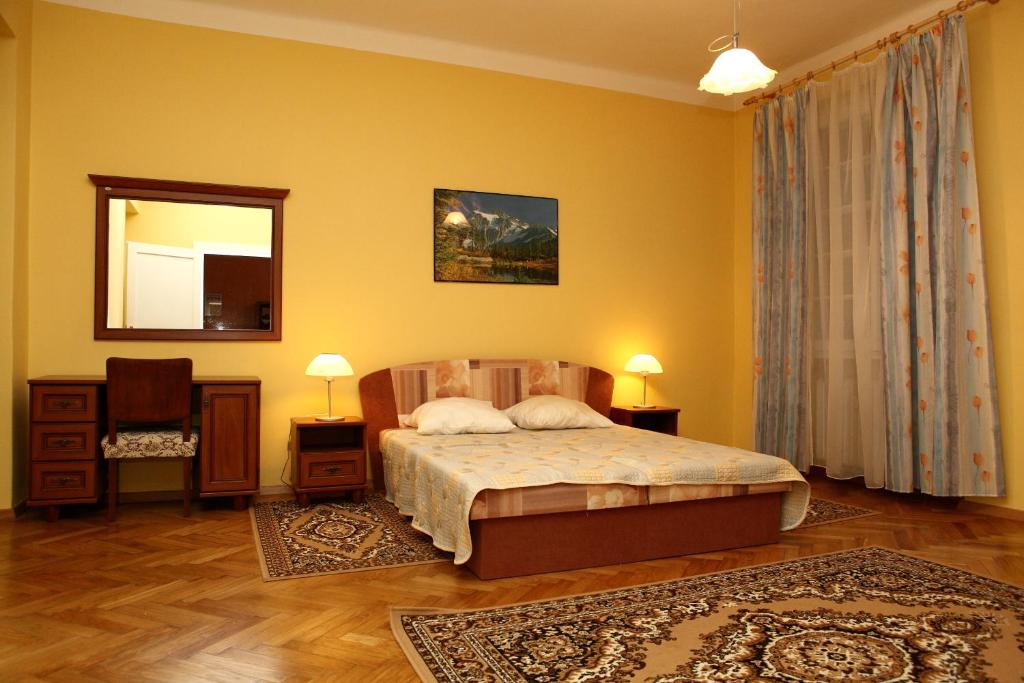 1 dormitorio con paredes amarillas, 1 cama y espejo en 7k - Apartmán Zámecký Vrch, en Karlovy Vary