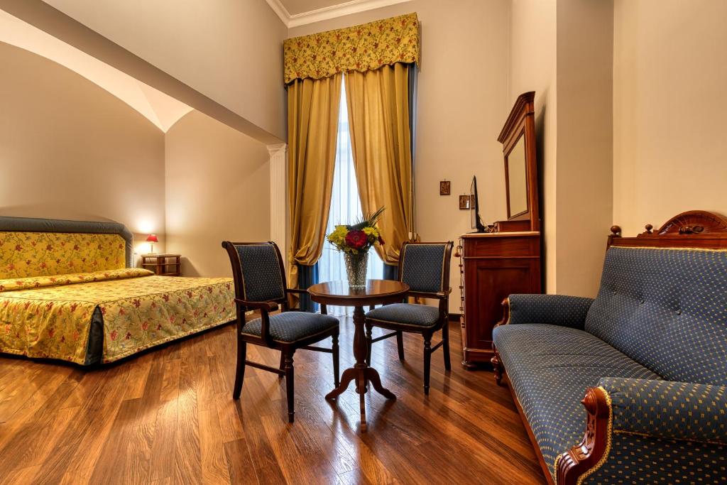 una camera con letto, tavolo e sedie di Decumani Hotel De Charme a Napoli
