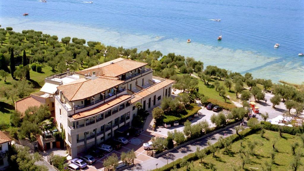 une vue aérienne sur un grand bâtiment à côté de l'eau dans l'établissement Hotel Ideal, à Sirmione