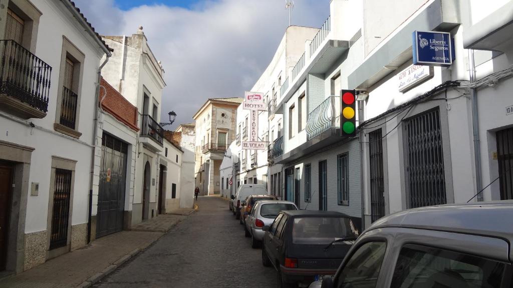 un semáforo en una calle con coches aparcados en Hostal el Volao, en Villanueva de Córdoba