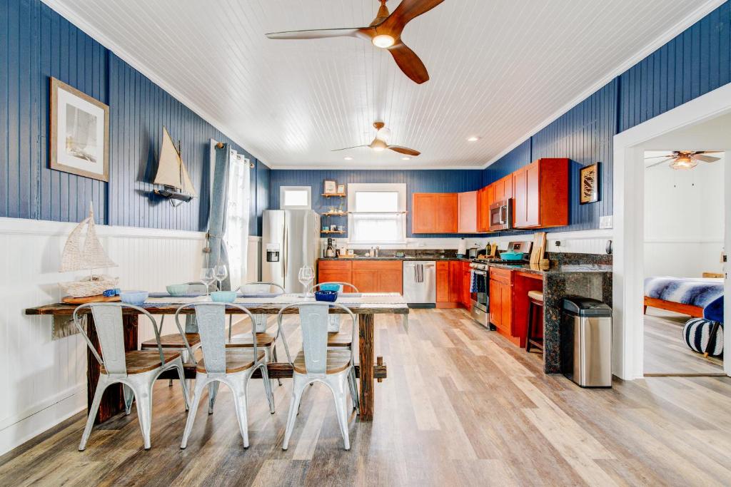 uma cozinha com paredes azuis e uma mesa e cadeiras em NEW Whaler Inn- Nautical Magic Hilo Downtown em Hilo