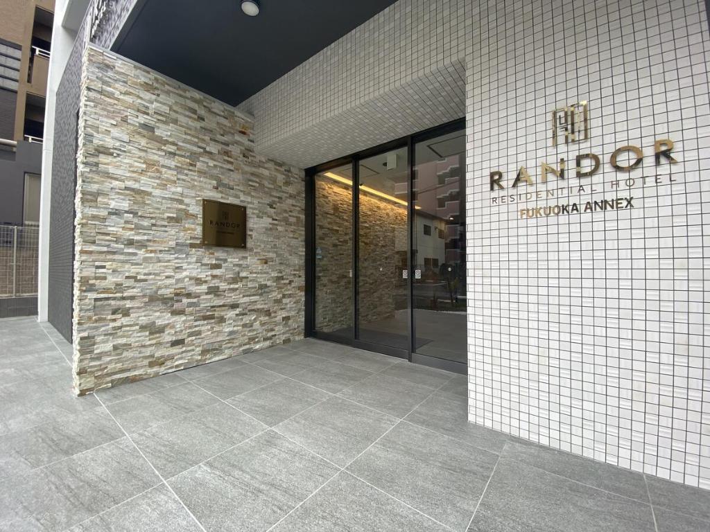 un hall d'un bâtiment avec un mur en briques dans l'établissement Randor Residential Hotel Fukuoka Annex, à Fukuoka