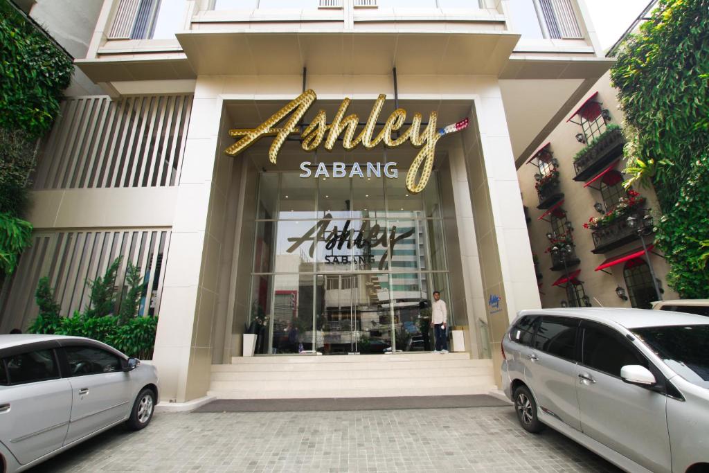 Ashley Sabang Jakarta في جاكرتا: سيارتين متوقفتين امام مول تجاري