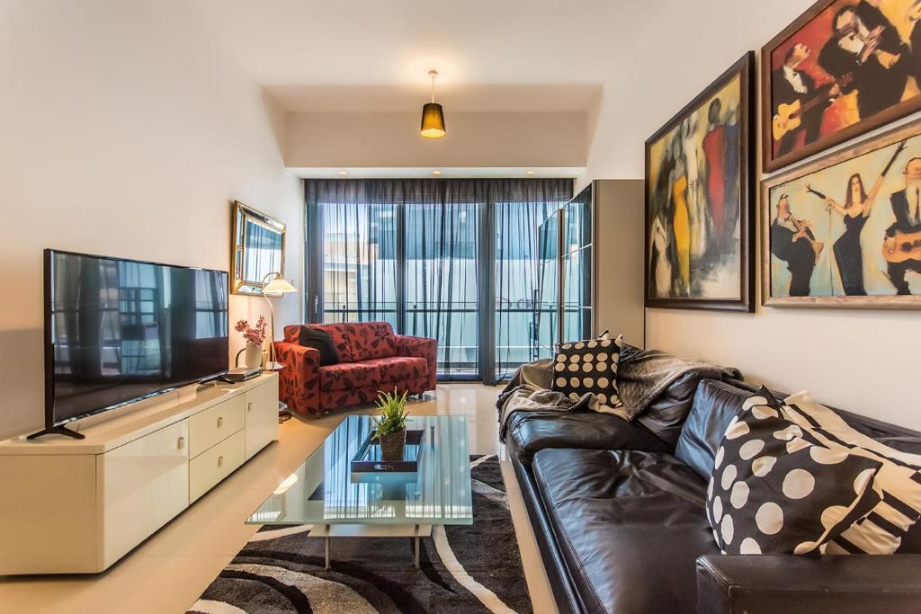 sala de estar con sofá de cuero y TV en Luxurious 2 bed Dubai Marina en Dubái