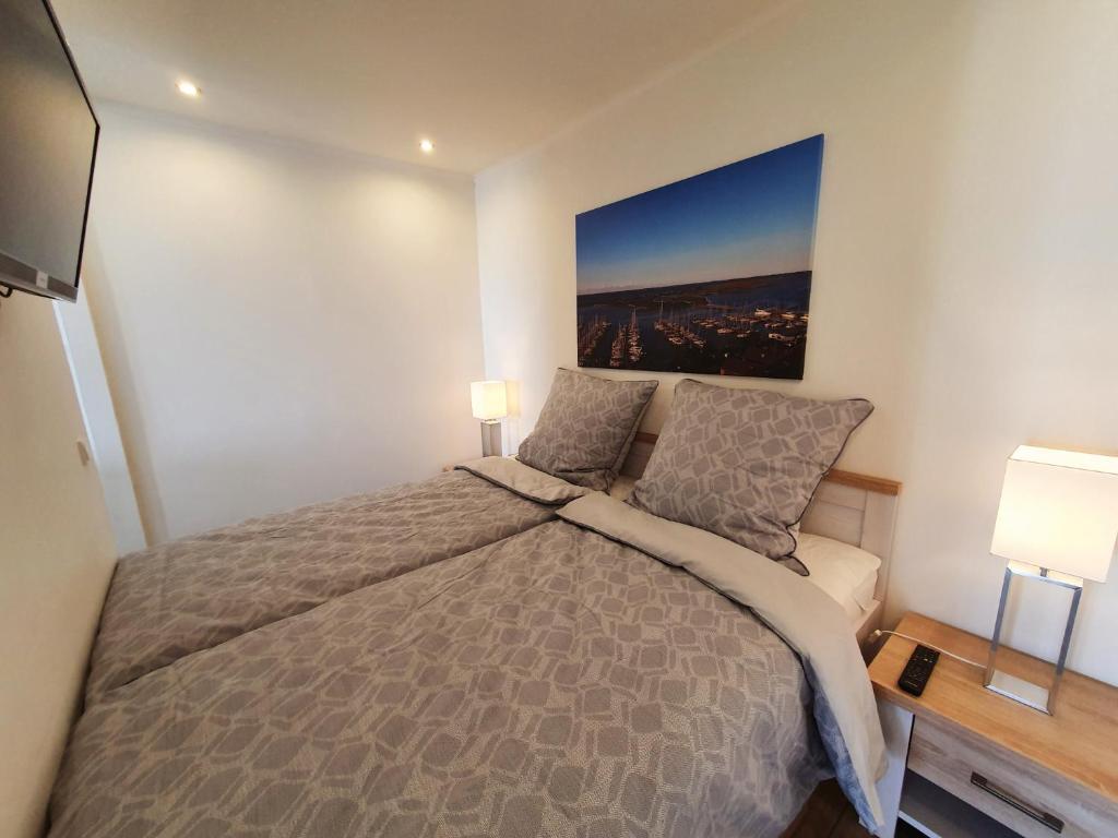 a bedroom with a large bed and a tv at Seeadler-F5 in Heiligenhafen