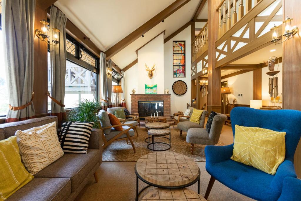 sala de estar con muebles azules y chimenea en Riverside Lodge, en Matsuno-cho