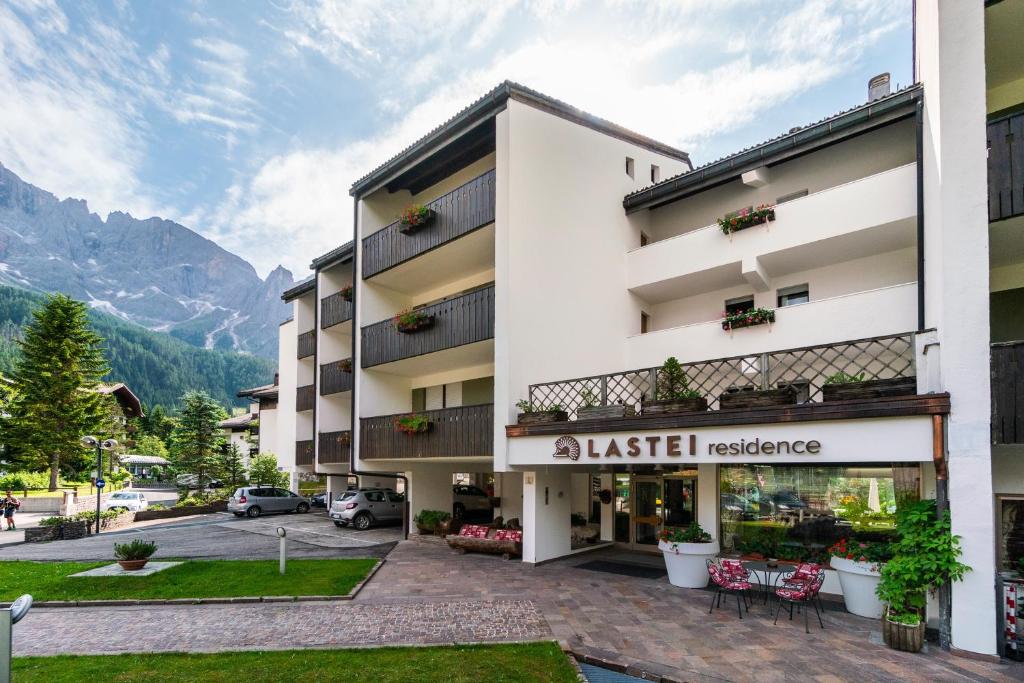 a building in a town with mountains in the background at Residence Lastei in San Martino di Castrozza
