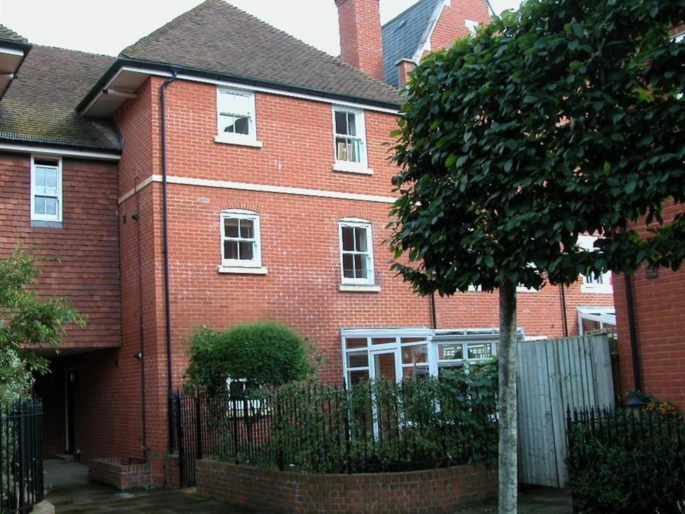 a red brick house with a fence in front of it at Charter Court in Salisbury