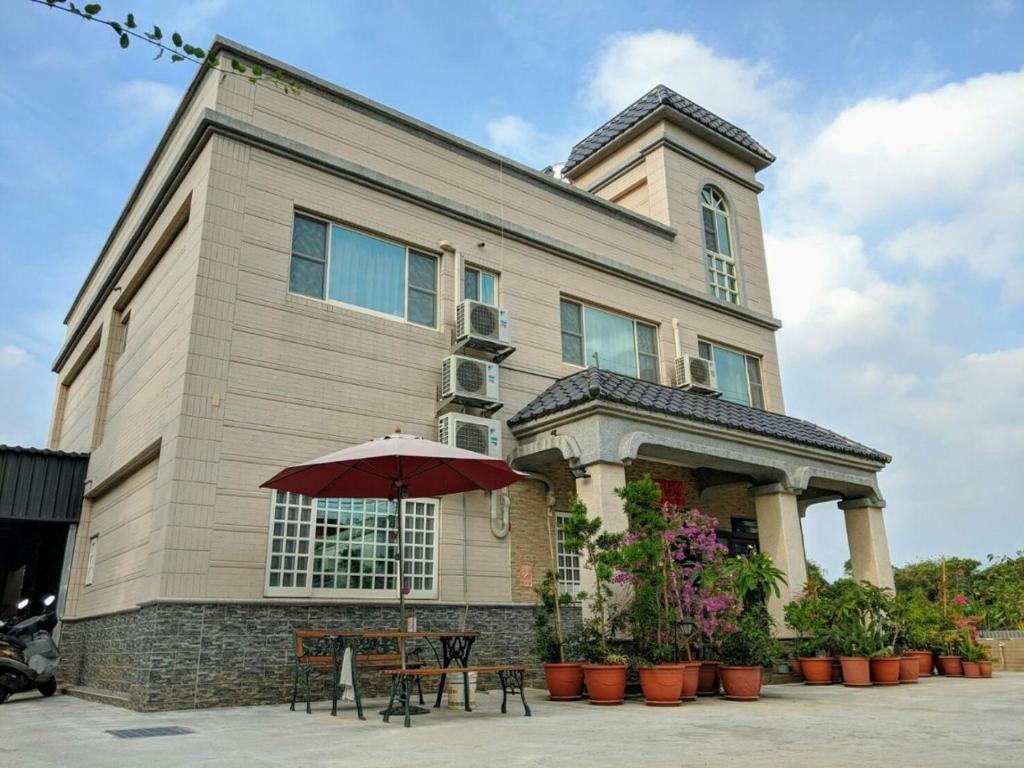 a building with an umbrella in front of it at Jin Xi Fu B&B in Jinning