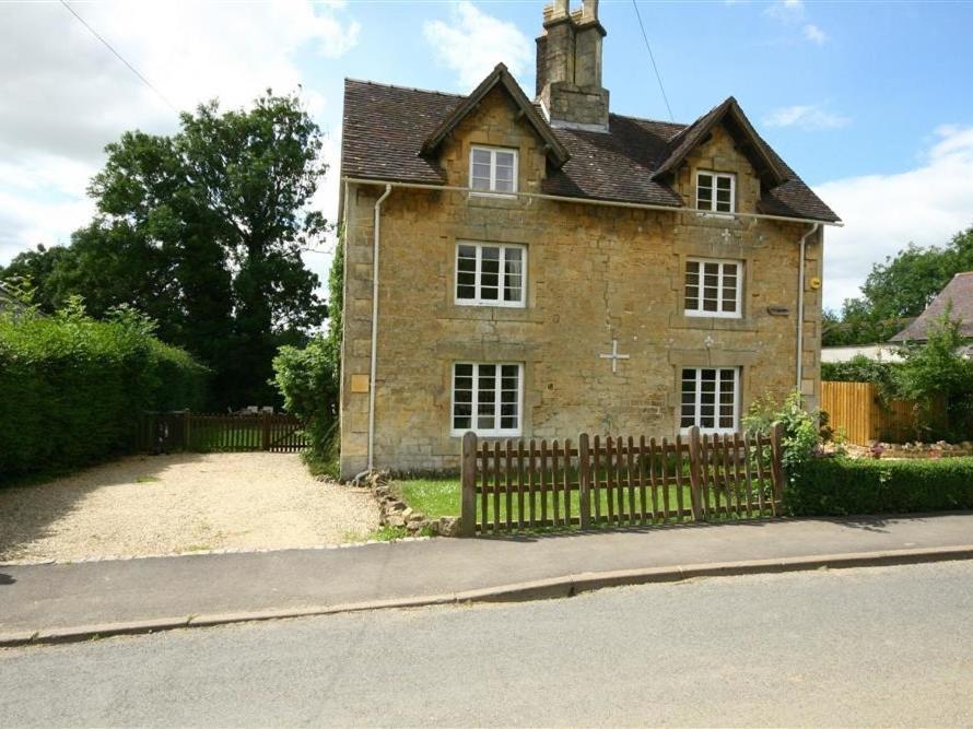 an old brick house with a fence in front of it at Elm View in Chipping Campden