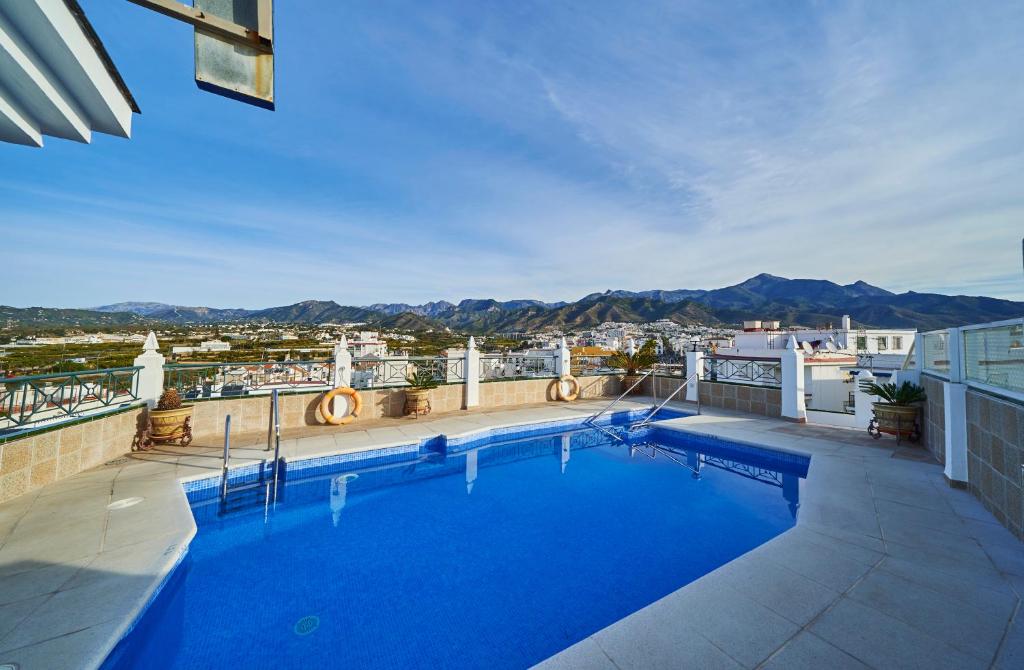 a beach with a pool and a swimming pool at Hotel Bajamar Centro in Nerja