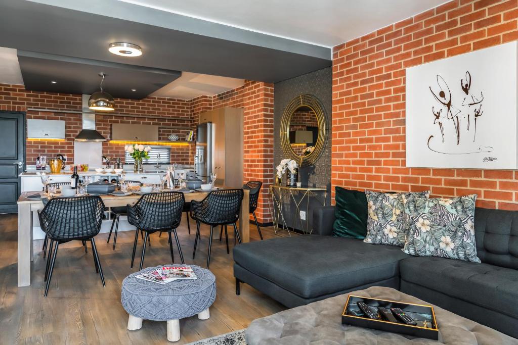 a living room with a couch and a brick wall at CAG The Vantage Rosebank in Johannesburg