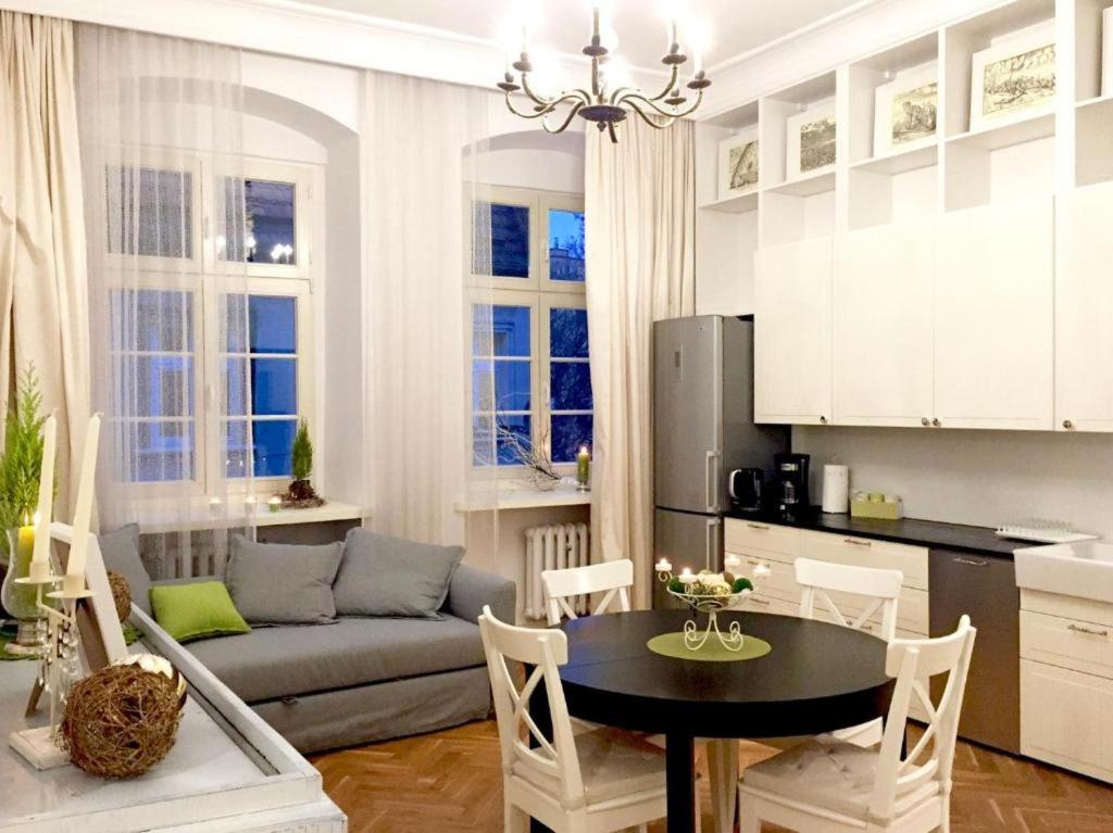 eine Küche und ein Wohnzimmer mit einem Tisch und einem Sofa in der Unterkunft Exclusive Old Town Apartment by Renters in Breslau