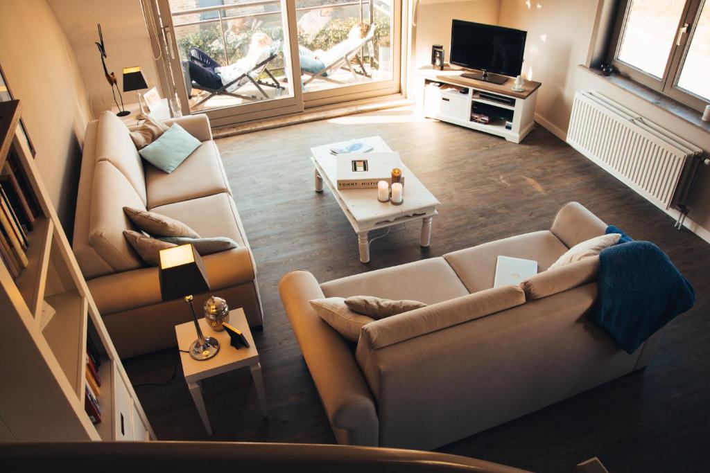 a living room with two couches and a tv at Residentie Duindoorn in Koksijde