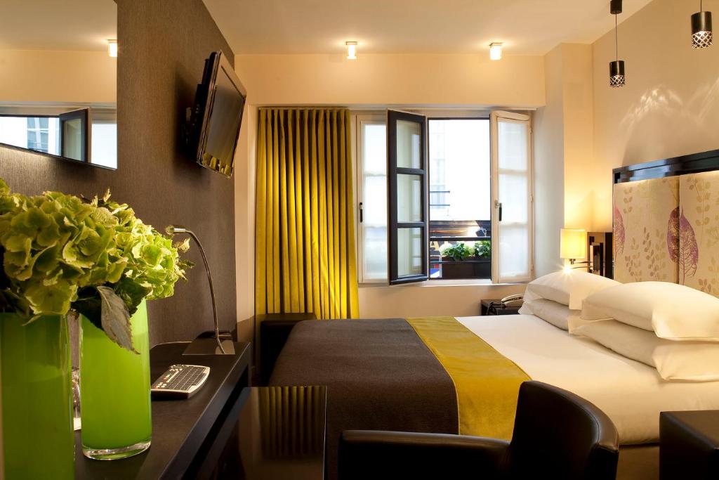 een hotelkamer met een bed en een raam bij Hôtel Caron le Marais in Parijs