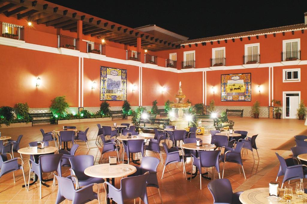 Habitación grande con mesas, sillas y una fuente. en Hotel Romerito, en Málaga
