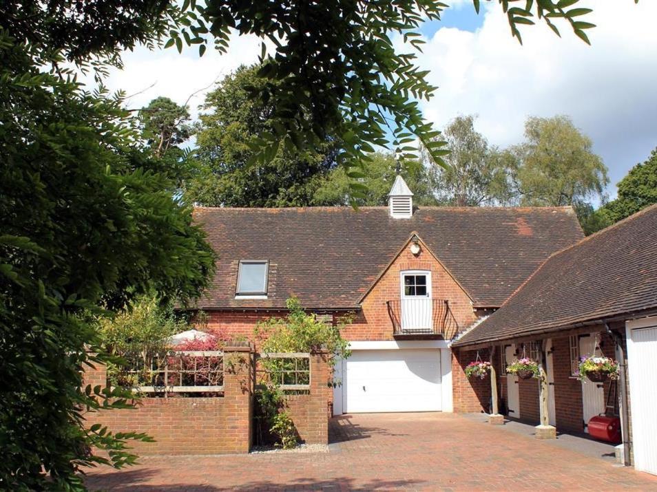 a red brick house with a white garage at Granary Cottage in Royal Tunbridge Wells