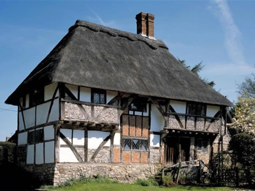 an old house with a thatched roof at The Yeoman's House in Bignor