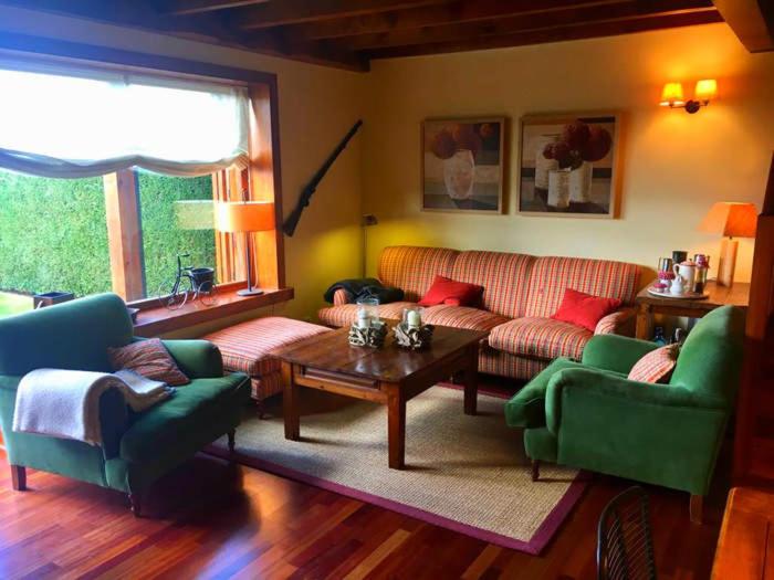 a living room with a couch and chairs and a table at Casa adosada con piscina en Agoustrina in Angoustrine