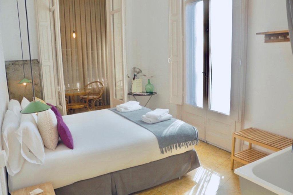 a bedroom with a large bed and a bathroom at La Casa Gran B&B in Barcelona