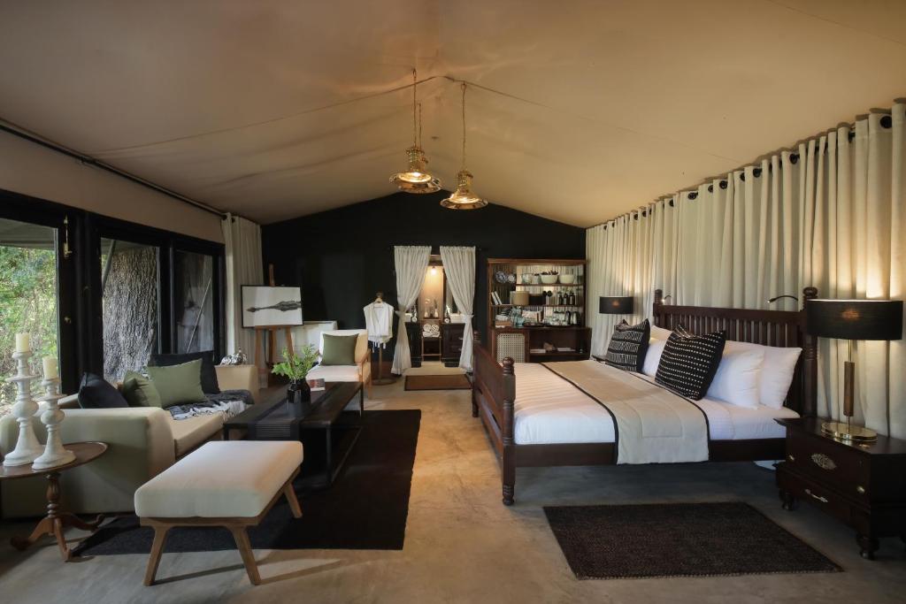 a bedroom with a bed and a living room at Leopard Trails Yala in Yala