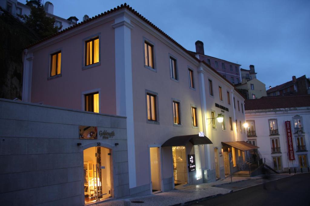 a white building with lit windows on a street at Sintra Boutique Hotel in Sintra