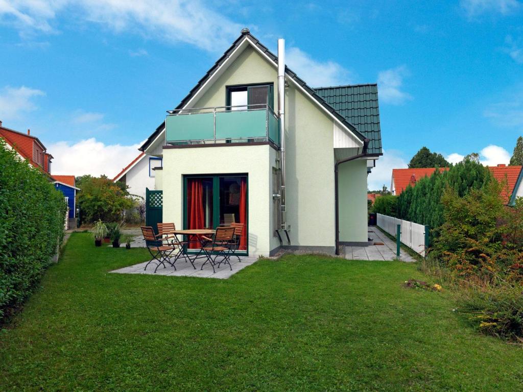 ein weißes Haus mit einem Tisch und Stühlen im Hof in der Unterkunft Inselhäuser Kaltenhof Inselhaus Poel 2 in Insel Poel