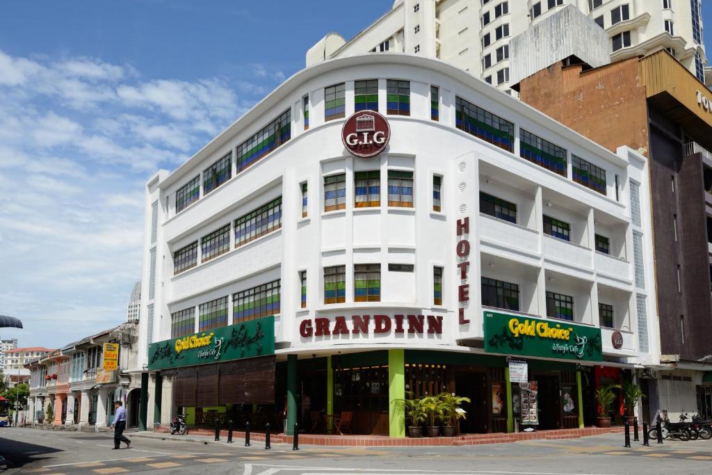um grande edifício branco com um cartaz em Grand Inn - Penang Road em George Town
