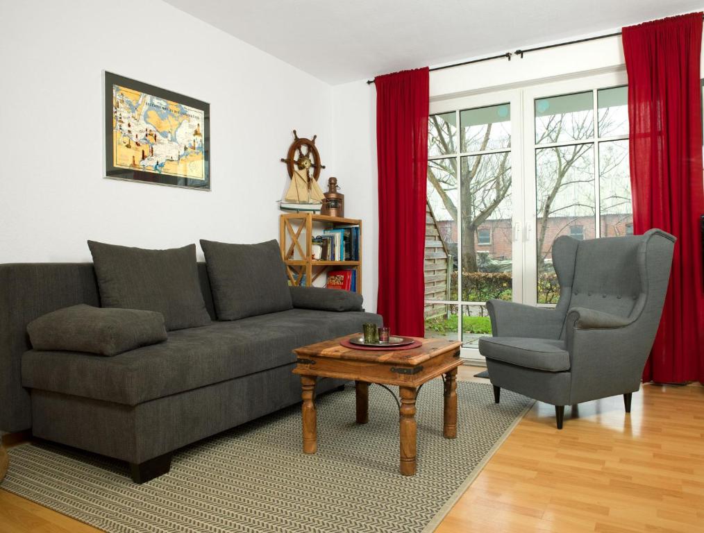 sala de estar con sofá, silla y mesa en Appartements Am Reiterhof Am Reitstall, en Poel