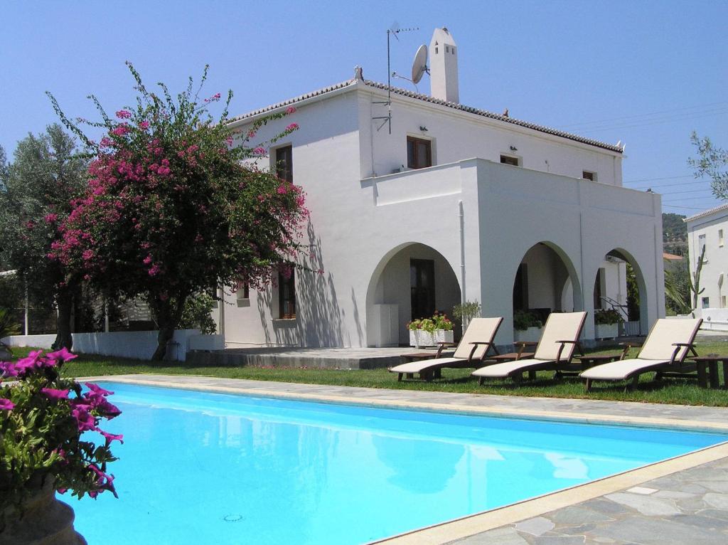 a villa with a swimming pool in front of a house at Villa Irini in Spetses