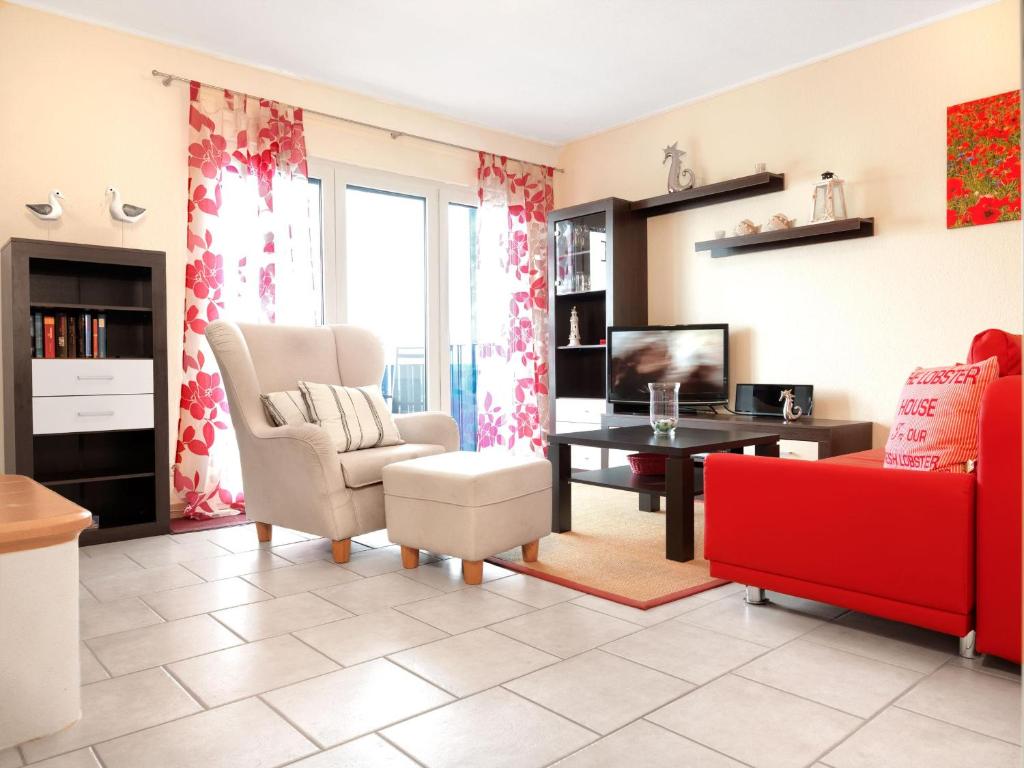 ein Wohnzimmer mit einem roten Sofa und einem Tisch in der Unterkunft Kleine Hafenkoje in Insel Poel