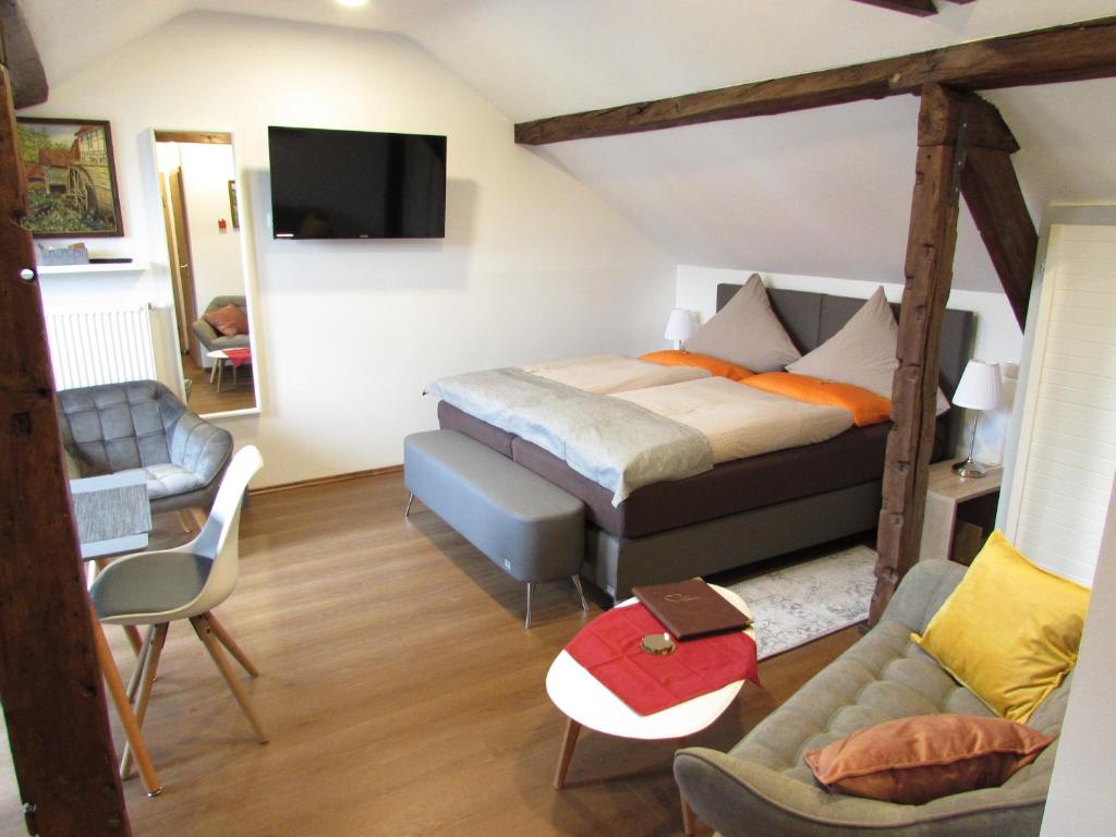 een slaapkamer met een bed en een bank bij Eifel Quartier Pension und Gasthof "Em Gardestüffje" in Mechernich