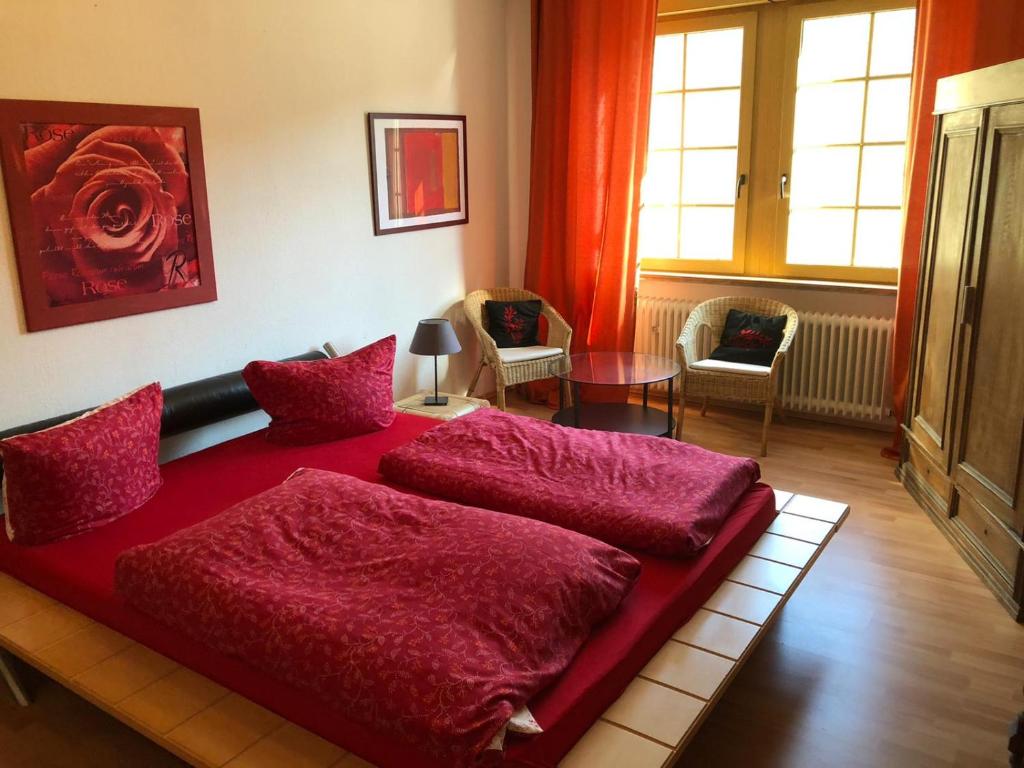 a bedroom with a red bed with red sheets at Gasthaus Rosenberg in Klotten