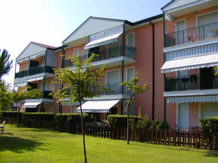 a large apartment building with a lawn in front of it at Villaggio Tirreno appartamento 02 in Rosolina Mare