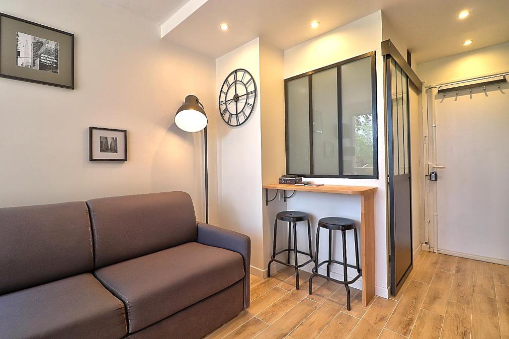 un salon avec un canapé et un bar dans l'établissement Studio 24h 24h Parking Terrasse Internet, à Toulouse