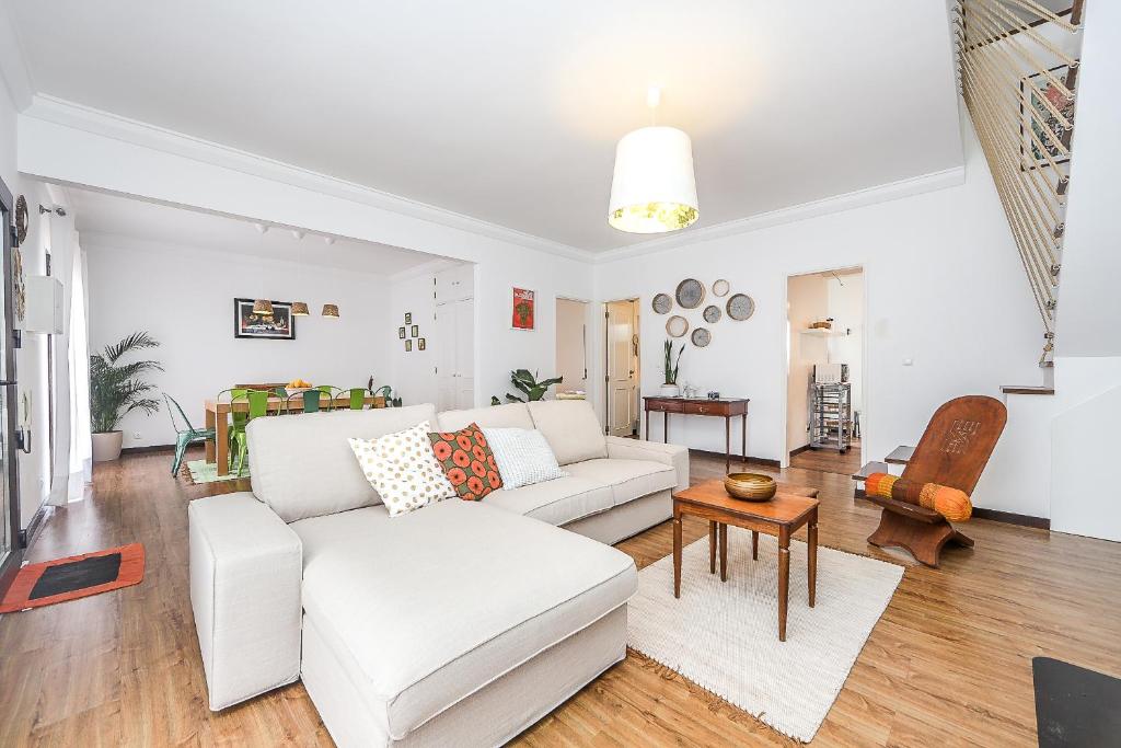 ein Wohnzimmer mit einer weißen Couch und einem Tisch in der Unterkunft Spacious Beach and Golf Villa in Charneca